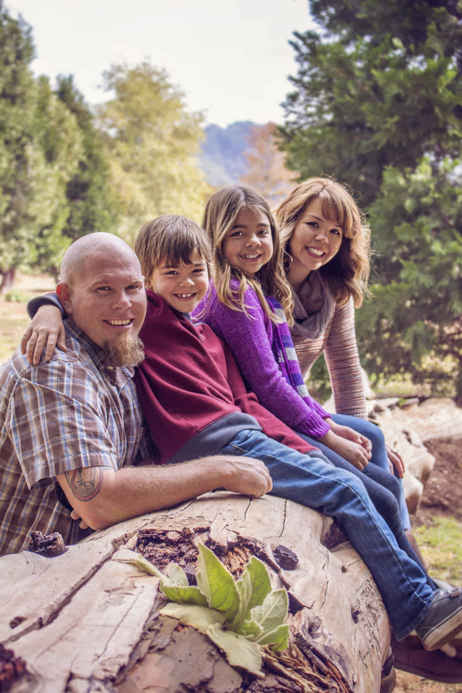 DIY Family Portrait Ideas on a Budget - mom and dad with two kids on a log