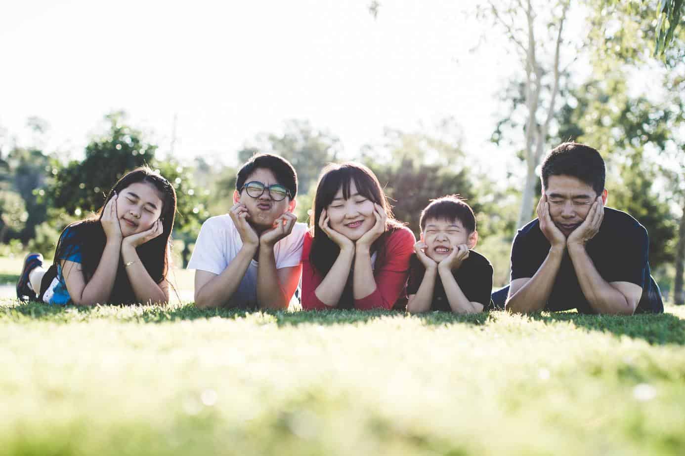 family portrait ideas outdoors - family lying on the grass