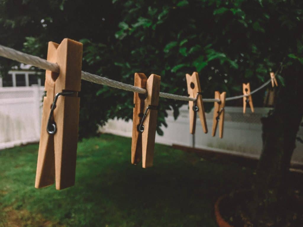 wooden clips on a line in a backyard - line drying is a good money saving habit