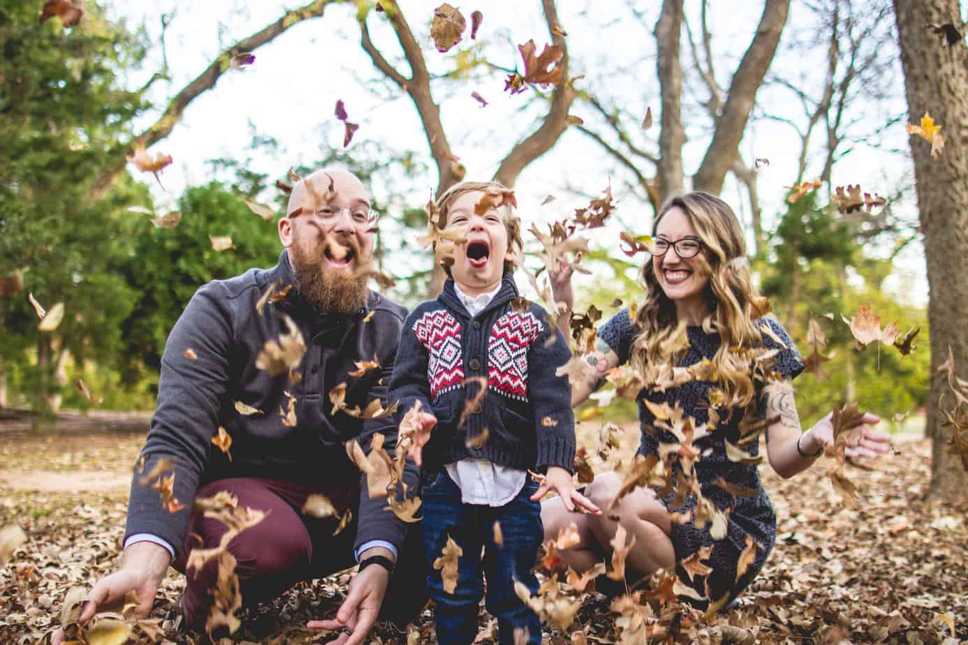 diy portrait ideas outdoors - family fall photoshoot with leaves in the air