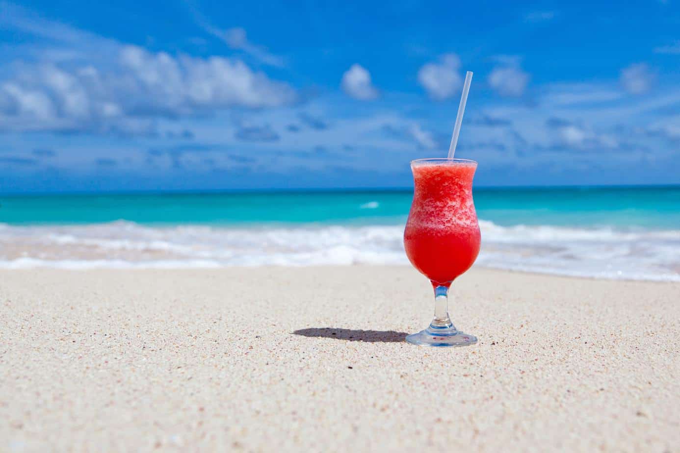 how to save money fast - cocktail on sandy beach