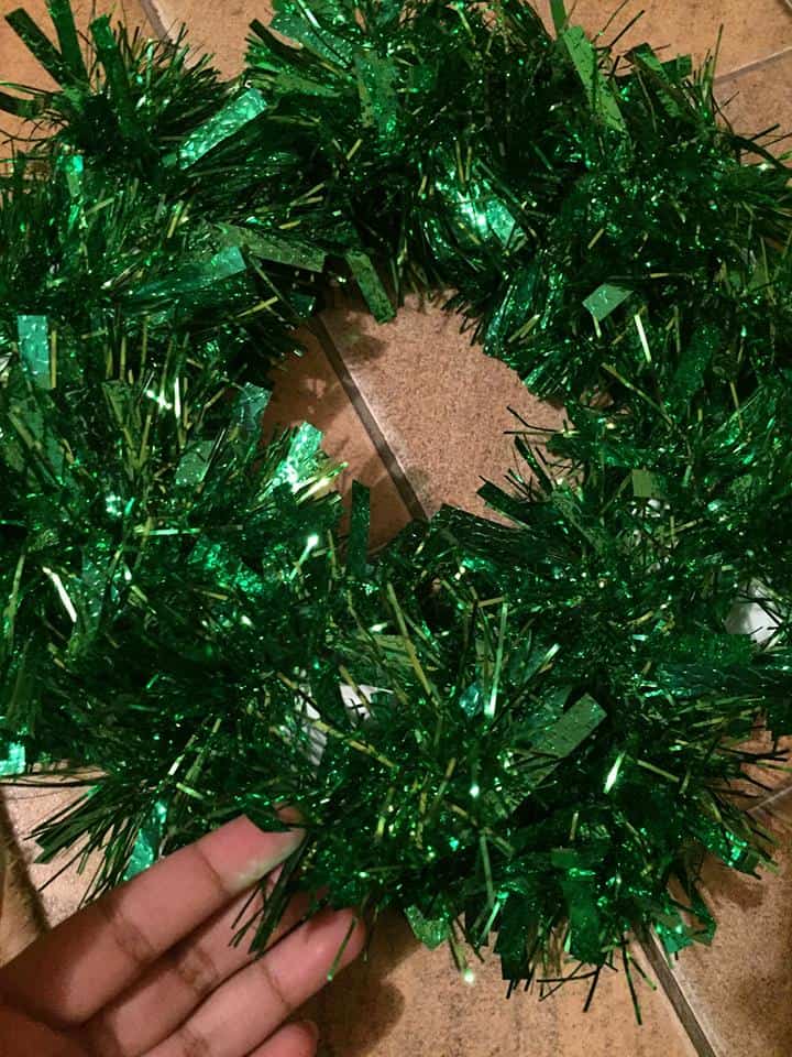 Paper plate wrapped in green tinsel DIY Christmas Wreath 