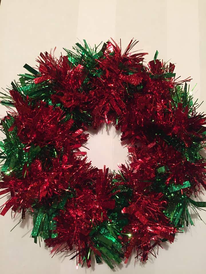 Paper plate wrapped in alternating bands of red and green tinsel DIY Christmas Wreath 