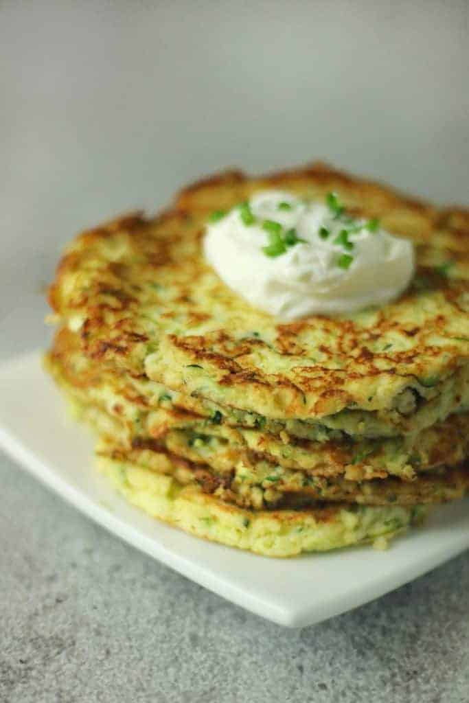 zucchini fritters stacked on a plate - cheap keto recipes