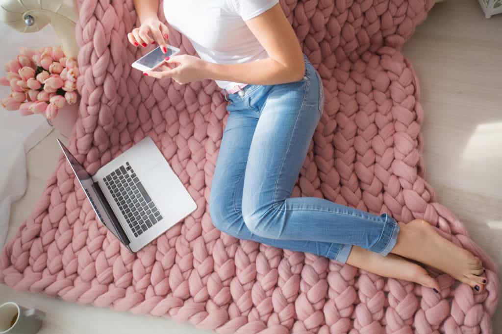 woman's legs on bed with laptop and phone - make money fast online