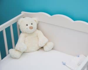 white teddy in white crib against blue wall - sell used items to make money fast today