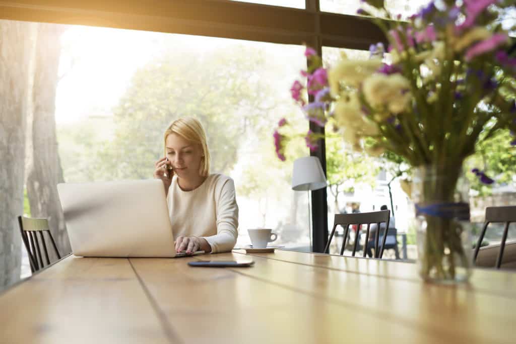 woman working on laptop at home - making extra money is a good money saving habit