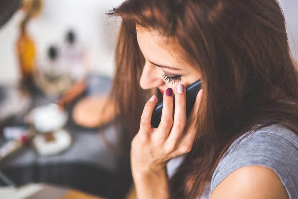 woman on phone negotiating rates for bills - good money saving habit