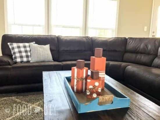 three orange wood block pumpkins on coffee table