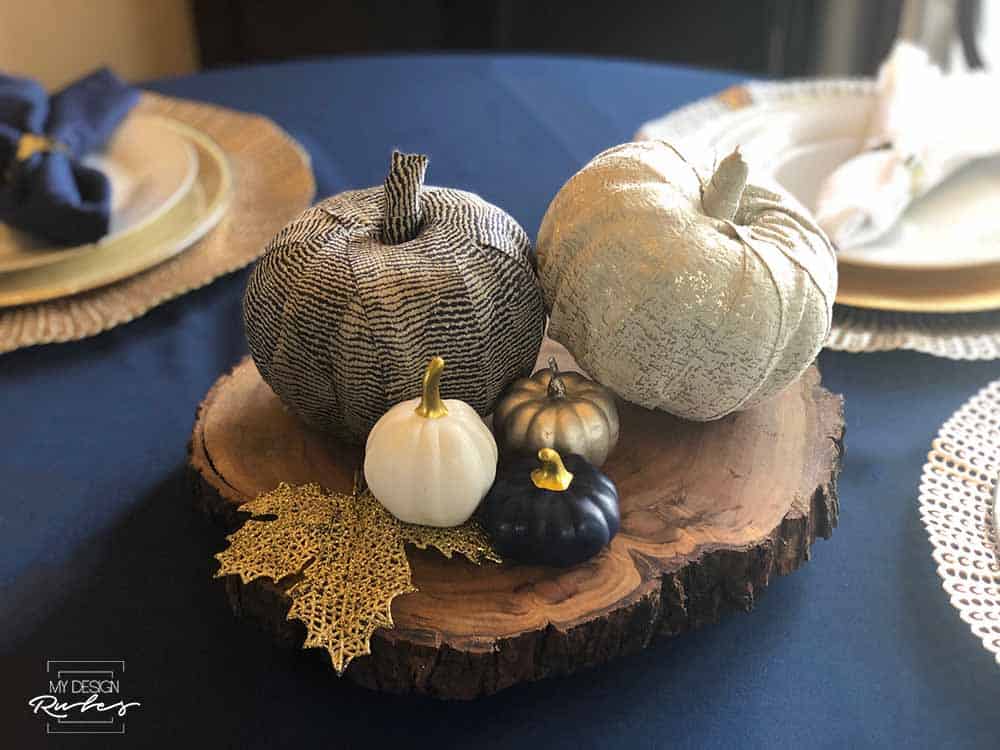 cloth decorated pumpkins on wood block on table