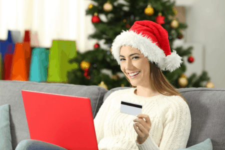 woman in santa hat with credit card