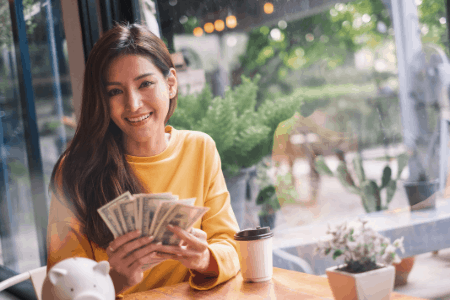 woman holding money - sell at consignment shops