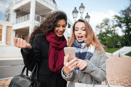 watch ads for money - 2 ladies watching cellphone