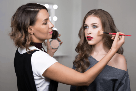 woman applying makeup on model - under the table jobs