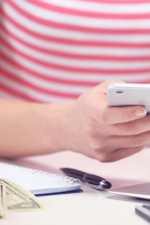 lady on phone with money on desk