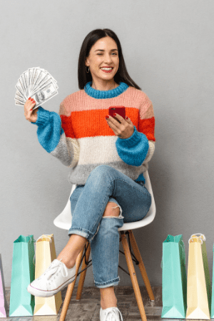 woman holding cell phone and cash