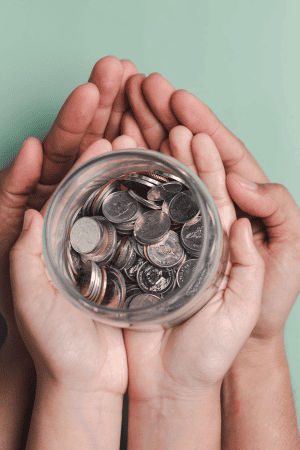 adult and kid's hands holding coins