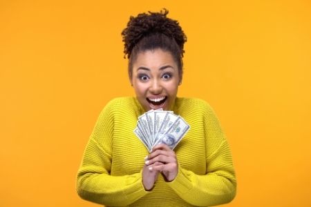 excited woman holding cash