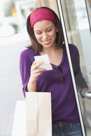 woman holding gift card exchange kiosk receipt