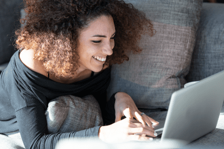 How to make $100 a day guaranteed - woman on couch with laptop