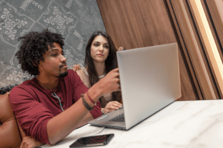 How to make 100 a day - man and woman looking at laptop