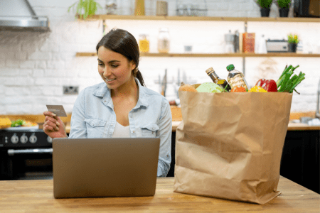 How to make 100 dollars a day - lady with groceries and laptop