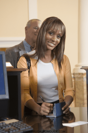 how to deposit a check for another person - woman at bank counter