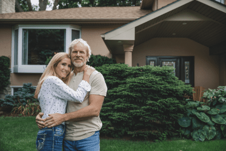 mortgage paid off - man and woman hugging in front of home