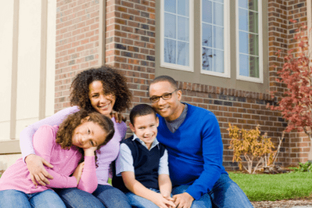 paid off house - family sitting on front step