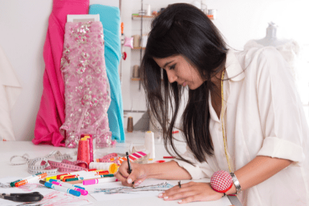 dress alterations near me - female tailor making a sketch of a dress