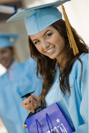 how much to give high school graduation - young woman wearing a graduation gown and holding a teddy bear