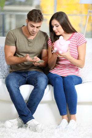 man with cash in hand sitting on couch with woman