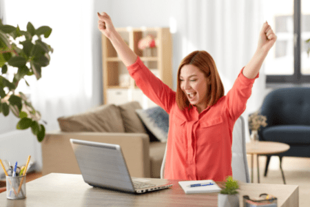 woman with laptop happy because of real money earning games