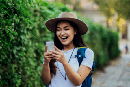 young woman with cellphone playing real money games