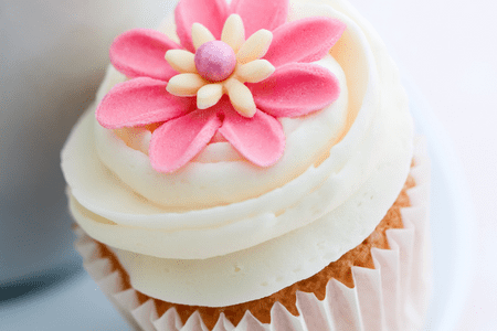 vanilla cupcake with frosting and flower