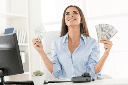 happy woman sitting at desk holding instant free money