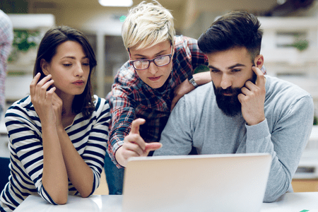 man and two women, with laptop, discussing what is digital real estate rental