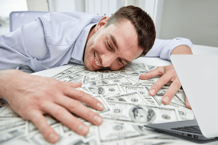 smiling man with face on table covered with free instant money