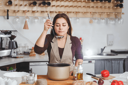 woman cooking soup in kitchen