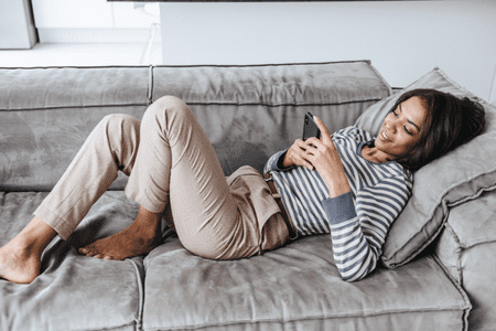 woman on couch with phone