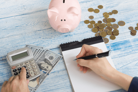 piggy bank with cash and a calculator - is a 64K salary good 