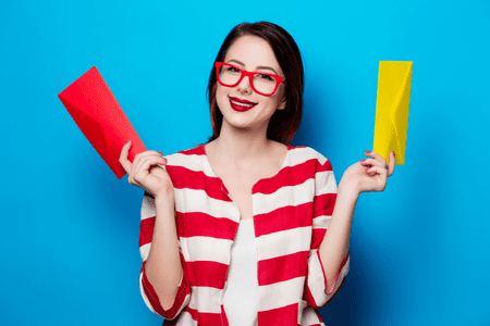 woman with colorful clothing stuffing envelopes at home