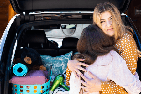 mom hugging daughter packing for moving out at 18
