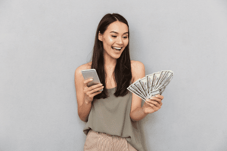 woman holding phone and cash