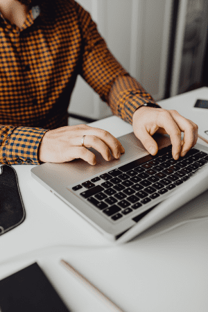 man doing grant writing work on laptop