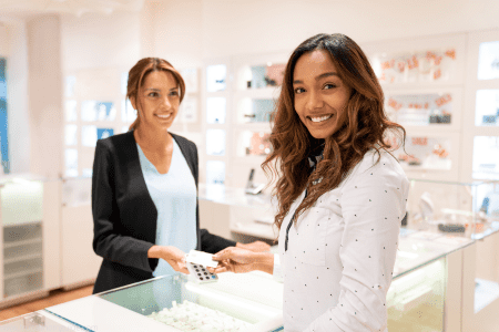 woman selling jewelry at counter - where to sell jewelry near me