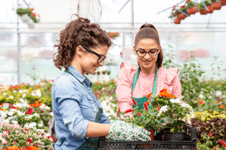 two women selecting flowers for hillside landscaping ideas on a budget