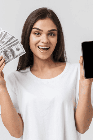 woman holding cash and cell phone