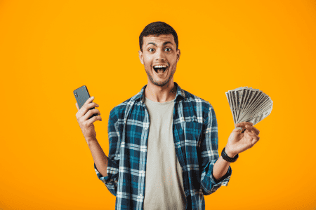 man holding cash and cell phone