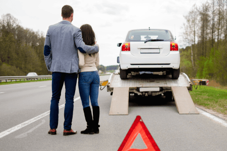 couple with car being towed